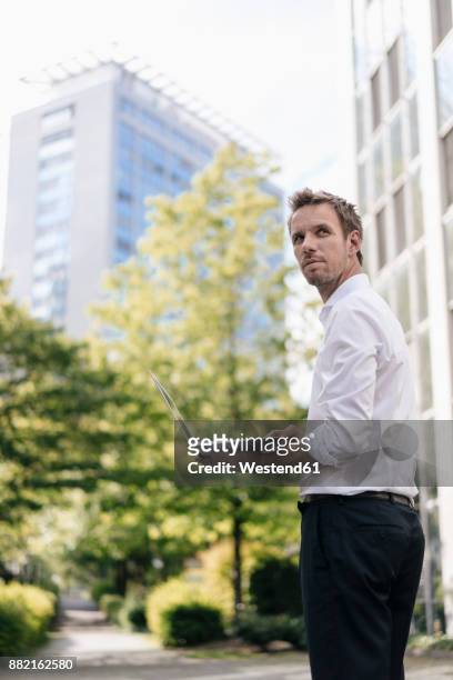 businessman using laptop in front of office building - essen ruhrgebiet stock-fotos und bilder