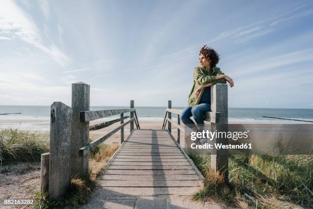 woman on boardwalk at the beach - boardwalk stockfoto's en -beelden