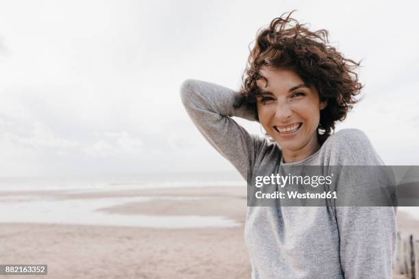 portrait of happy woman on the beach - zeeland netherlands stock pictures, royalty-free photos & images