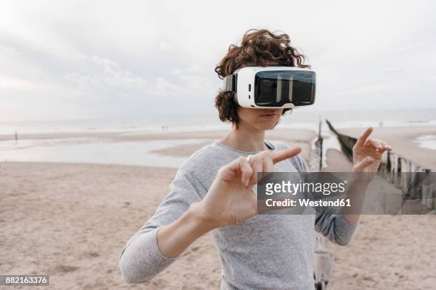 Woman on the beach wearing VR glasses