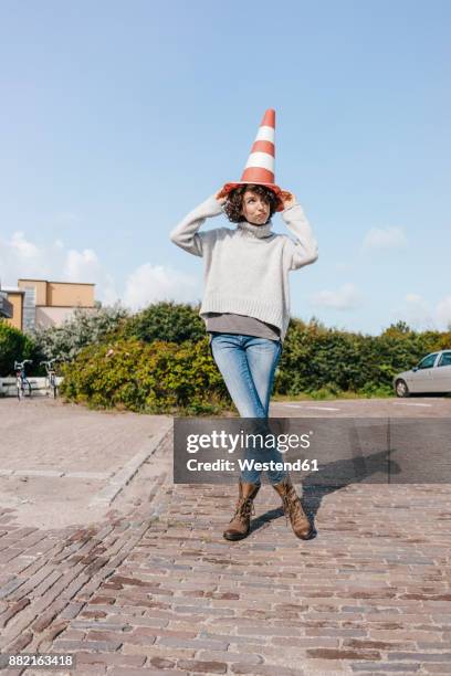 playful woman with traffic cone - safety cone stock pictures, royalty-free photos & images