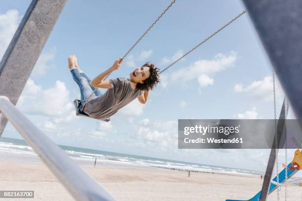 happy woman on a swing on the beach - woman on swing stock pictures, royalty-free photos & images