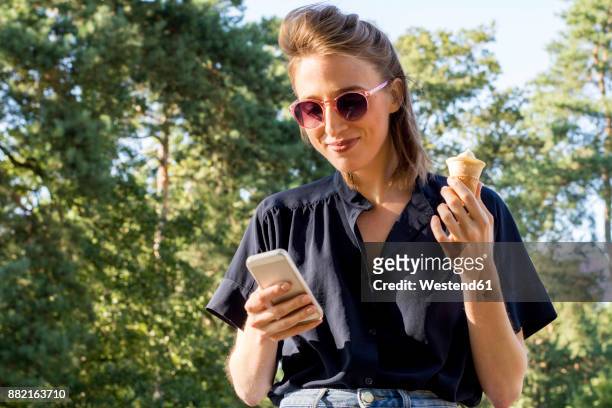 young woman with ice cone using smartphone - woman ice cream stock pictures, royalty-free photos & images