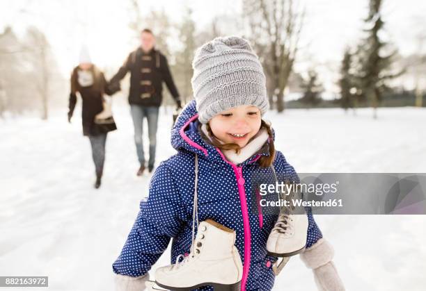 little girl going ice skating with her parents - eislaufen stock-fotos und bilder