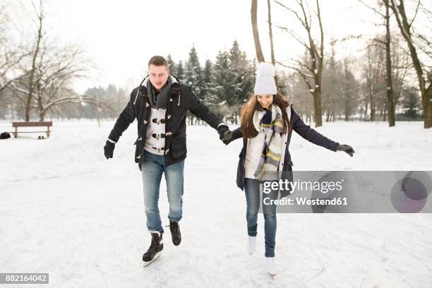 couple ice skating on a frozen lake - couple skating stock pictures, royalty-free photos & images