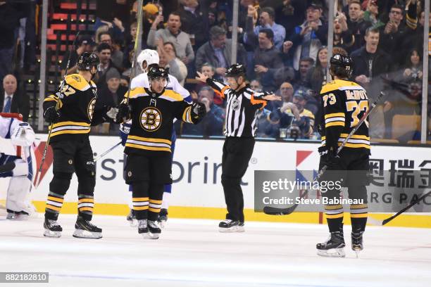 Patrice Bergeorn, Brad Marchand and Charlie McAvoy of the Boston Bruins celebrate a goal in the first period against the Tampa Bay Lightning at the...
