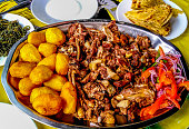 Sharing platter of a traditional Kenyan dish, Nyama choma and accompaniments of kachumbari salad, sukuma wiki, chapati and roast potatoes.