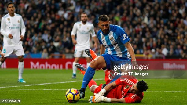 Kiko Casilla of Real Madrid and Borja Baston of Malaga battle for the ball during the La Liga match between Real Madrid and Malaga at Estadio...