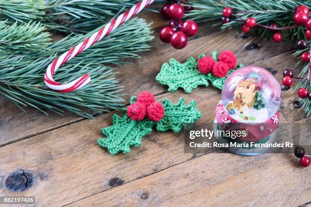 christmas decoration: santa’s magic crystal ball with reindeer inside, crochet mistletoe leaves, candy cane, fir tree branches and mistletoe seed on rustic wooden background.selective focus and copy space. - crystal christmas tree ornaments fotografías e imágenes de stock