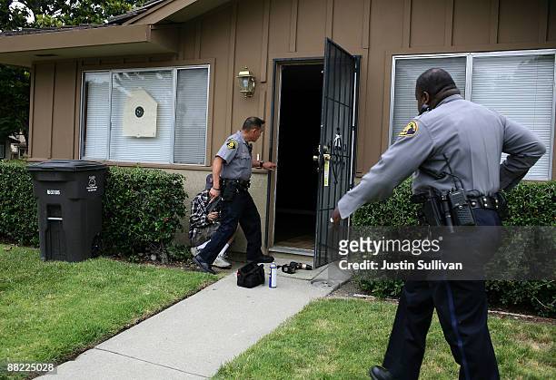 Alameda County Sheriff deputies Ken Kong and Ken Cammack move in to search a foreclosed home after a locksmith broke the lock off the door as they...
