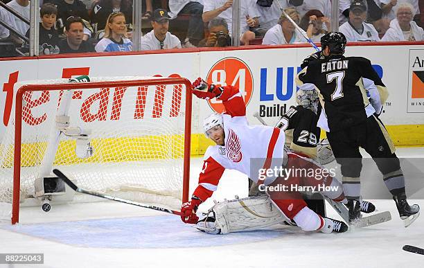 Dan Cleary of the Detroit Red Wings falls to the ice after Darren Helm scored in the first period against goaltender Marc-Andre Fleury and Mark Eaton...