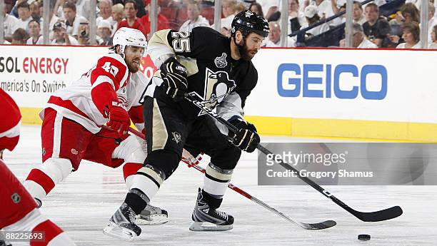 Maxime Talbot of the Pittsburgh Penguins caries the puck ahead of Henrik Zetterberg of the Detroit Red Wings during Game Four of the 2009 Stanley Cup...
