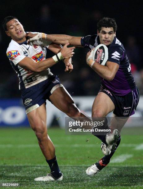 Greg Inglis of the Storm is tackled by Israel Folau of the Borncos during the round 13 NRL match between Melbourne Storm and Brisbane Broncos at...