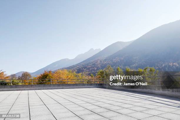 empty parking area with distant mountains on sunny day - balustrade stock pictures, royalty-free photos & images