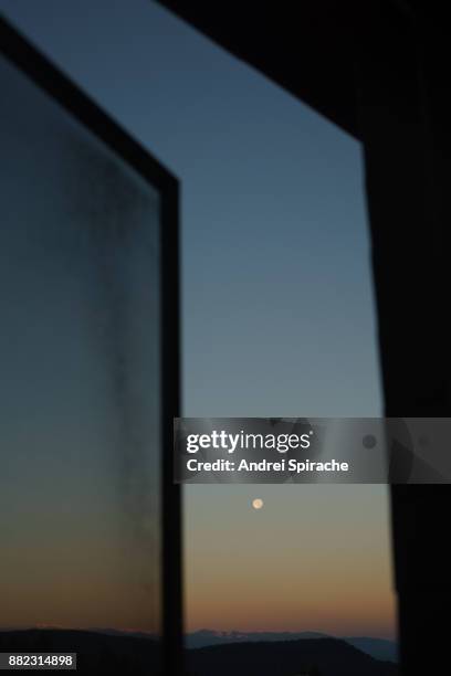 the moon at dusk seen thru window - open romania stock pictures, royalty-free photos & images