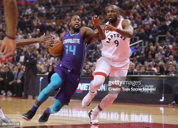 Michael Kidd-Gilchrist of the Charlotte Hornets goes to the basket against Serge Ibaka of the Toronto Raptors during NBA game action at Air Canada...