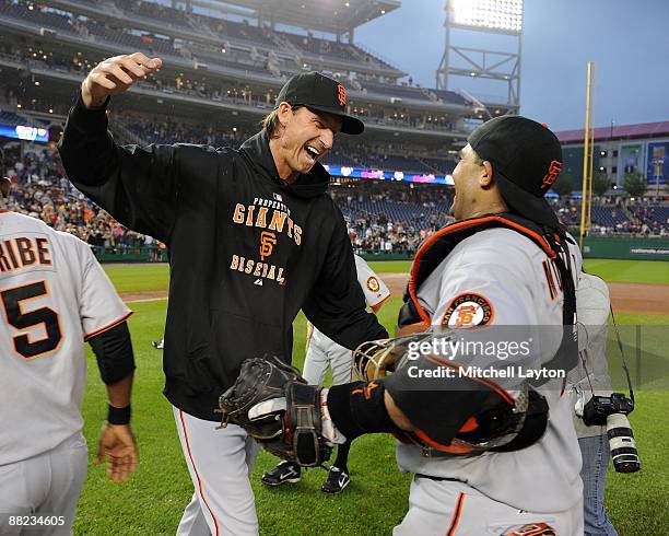 Randy Johnson of the San Francisco Giants celebrates his 300th win with teammate catcher Bengie Molina after the game against the Washington...