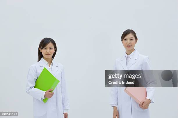 portrait of two female reserchers, holding files - blouse blanche femme photos et images de collection