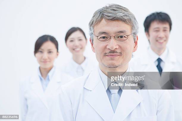 portrait of scientists, people in background - smiling woman on gray background 50 stock pictures, royalty-free photos & images