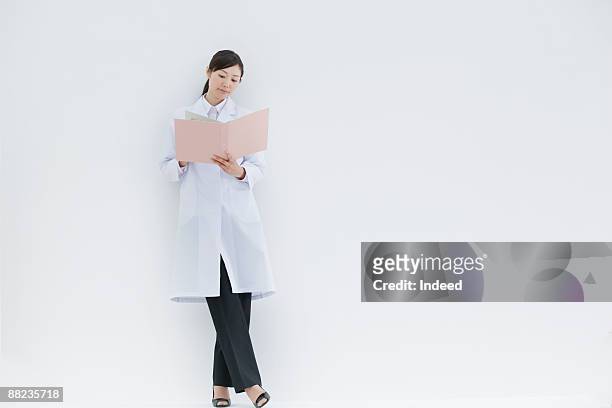 female scientist standing and looking at file - scientist full length stock pictures, royalty-free photos & images