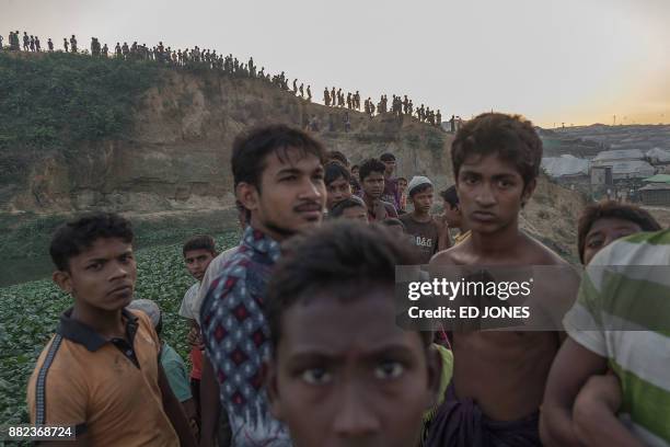 This picture taken on November 26 shows Rohingya Muslim refugees looking on near Kutupalong refugee camp at Cox's Bazar. The plight of the Rohingya...