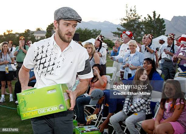 Singer Justin Timberlake hands out Xbox 360 video game consoles to youth from Shriners Hospitals during a golf clinic for kids during the Justin...