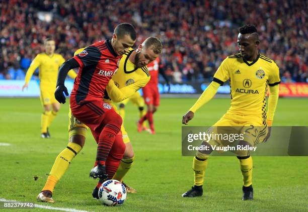 Sebastian Giovinco of Toronto FC battles for the ball with Josh Williams and Harrison Afful of Columbus Crew SC during the first half of the MLS...