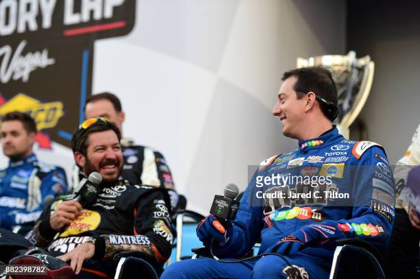 Monster Energy NASCAR Cup Series champion Martin Truex Jr., driver of the Furniture Row/Denver Mattress Toyota talks with Kyle Busch, driver of the...