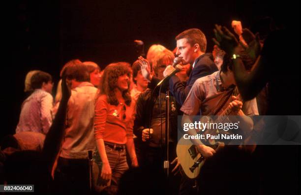 The band Madness, with fans onstage, perform at the Park West in Chicago, Illinois, March 1, 1980. Singer Suggs is on the microphone.
