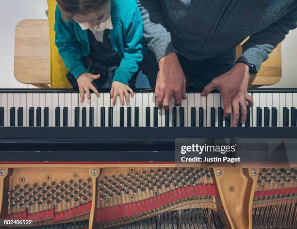 father and daughter playing the piano - practicing piano stock pictures, royalty-free photos & images