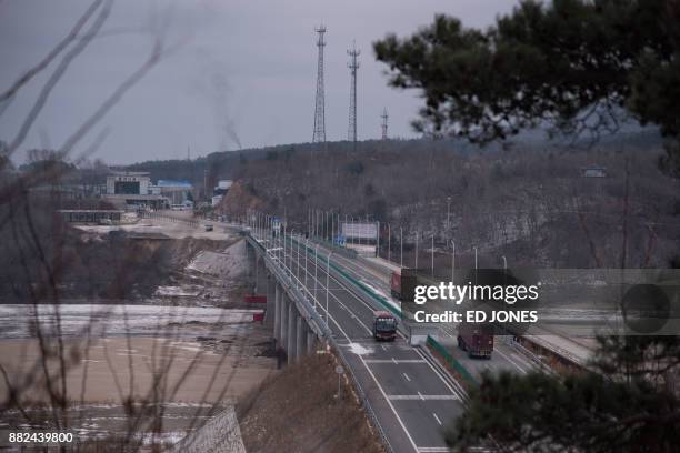 In a photo taken on November 21 vehicles make their way across a bridge across the Tumen river marking the border between North Korea and China and...