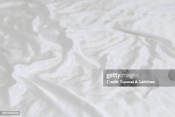 white shiny and soft polyester satin sheet background. shallow depth of field. - white satin 個照片及圖片檔