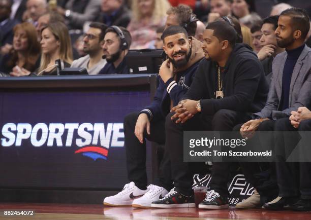 Rap artist and team ambassador Drake of the Toronto Raptors watches from his courtside seat against the Charlotte Hornets during NBA game action at...