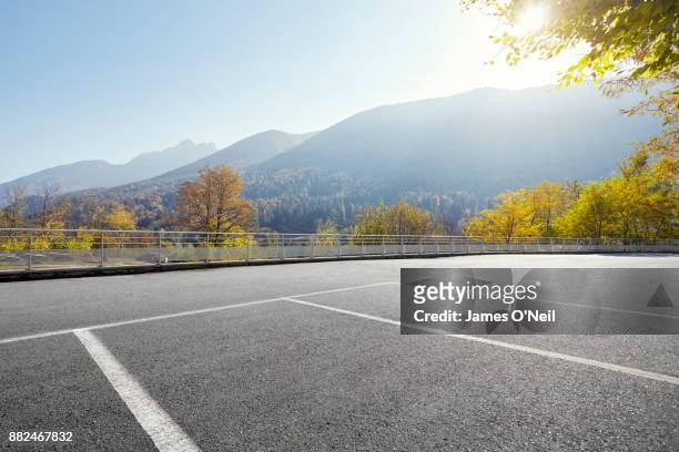 empty parking area with distant hills on sunny day - parking foto e immagini stock