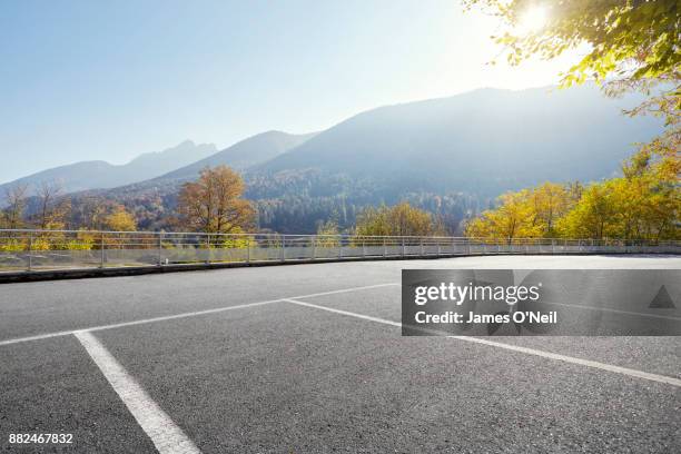 empty parking area with distant hills on sunny day - parking lot stock pictures, royalty-free photos & images