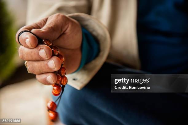 greek hand swinging komboloi [worry beads] - greek worry beads stock pictures, royalty-free photos & images