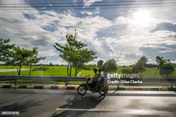 N"nA Burmese family driving along a road leading from Naypyitaw on August 31, 2016. The city first became the capital of Myanmar in 2006 after the...