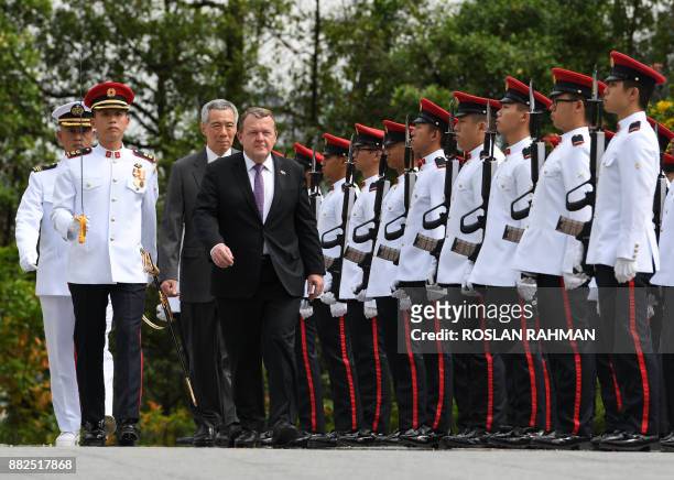 Denmark's Prime Minister Lars Lokke Rasmussen is followed by Singapore's Prime Minister Lee Hsien Loong as they inspect a guard of honour during a...