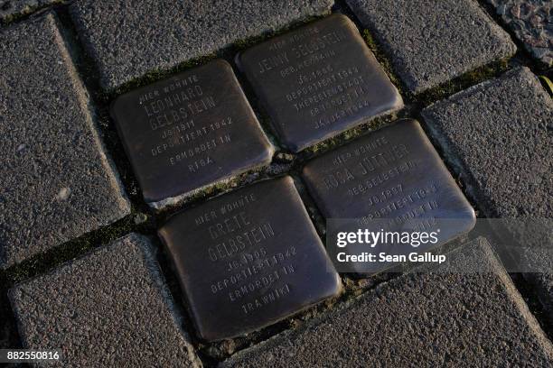 So-called "Stolpersteine", literally translated as "stumbling stones," lie in silent testimony in the sidewalk in front of the location where members...