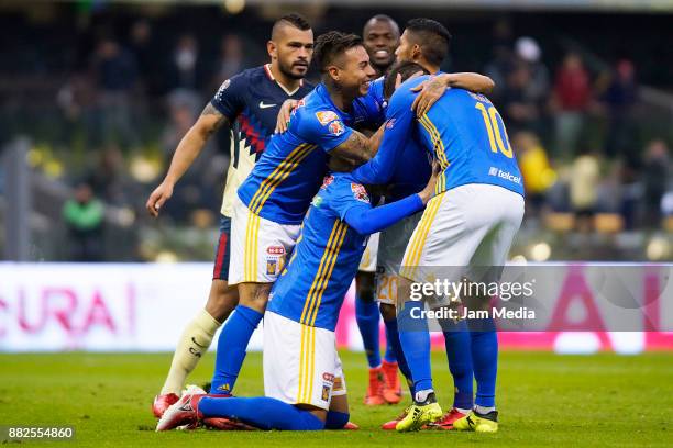 Juninho of Tigres celebrates with teammates after scoring the first goal of his team during the semifinal first leg match between America and Tigres...