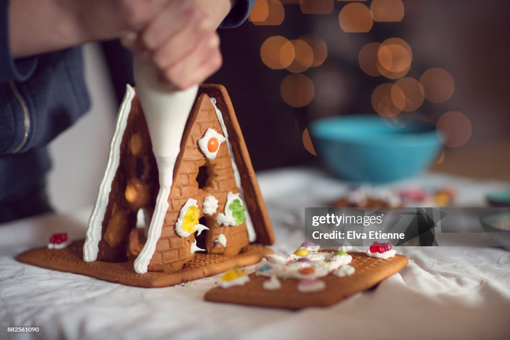 Teenager decorating gingerbread house