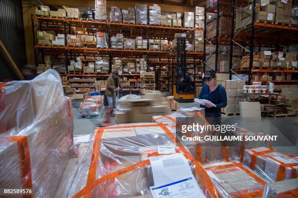 This photograph taken on November 28 shows workers packaging goods at the Cléopâtre glue company warehouse at Ballan-Mire in central France.