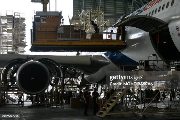 Engineers inspect a Malaysia Airlines Airbus A330-300 aircraft inside a hangar at an engineering complex adjacent to the Kuala Lumpur International...