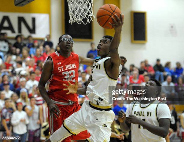 Paul VI Panthers guard Brandon Slater drives to the hoop around St. John's Cadets forward Richard Njoku in the second half December 10, 2015 in...