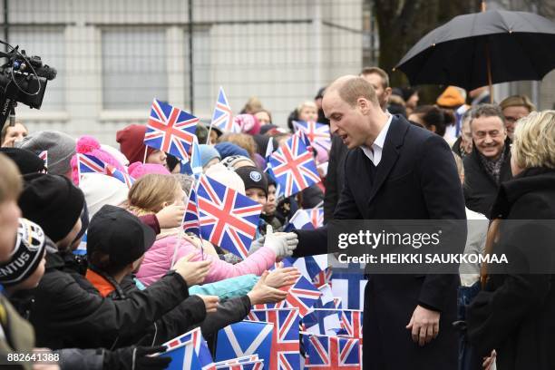 Britain's Prince William, Duke of Cambridge, greets pupils during a visit at Lauttasaari primary school in Helsinki, Finland, on November 30, 2017....