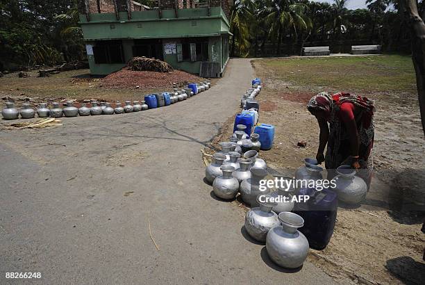 Displaced Bangladeshi villager puts her water pot in line to collect drinking water in Nildumur on the outskirts of Satkhira some 400 km from Dhaka...