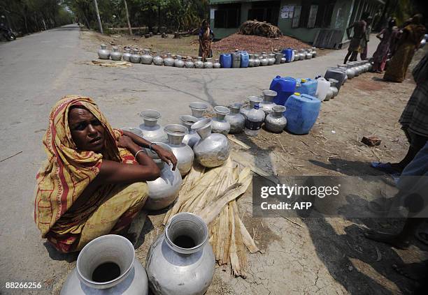 Displaced Bangladeshi villager puts her water pot in line to collect drinking water in Nildumur on the outskirts of Satkhira some 400 km from Dhaka...