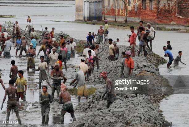 Bangladeshi villagers rebuild an embankment in Padmapukir on the outskirts of Satkhira some 400 km from Dhaka on June 3, 2009. Bangladesh and India...
