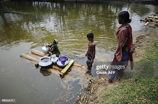 Flood affected Bangladeshi villagers transport pots of water on rafts in Koikhali on the outskirts of Satkhira some 400 km from Dhaka on June 3,...