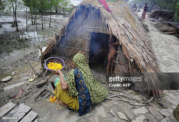 Displaced Bangladeshi villagers prepare food in a makeshift shelter by an embankment in Padmapukir on the outskirts of Satkhira some 400 km from...